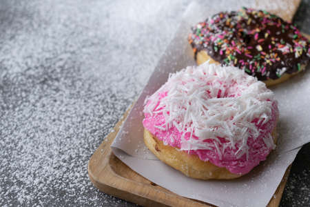 Donut with chocolate glazed and strawberry glazed in wooden tray on concrete table.の写真素材