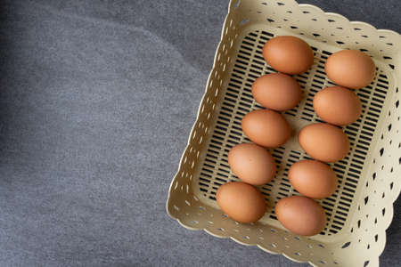 Chicken egg in basket on the concrete table background.の写真素材