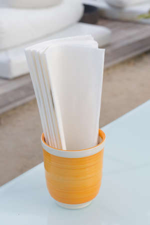 Tissue in yellow glass on glass table.の写真素材