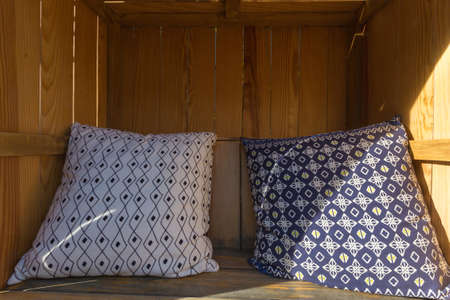 Pillow on wooden seat with shade for relax.