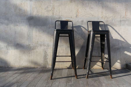 Steel bench in the park on wooden floor with concrete background.の写真素材