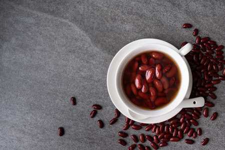 Sweet boiled red beans in white cup on concrete table.の写真素材