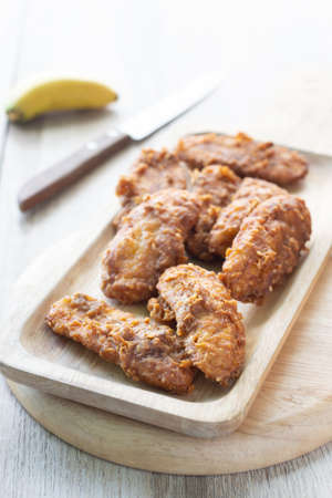 Deep fried banana in wooden dish with banana on table.の写真素材
