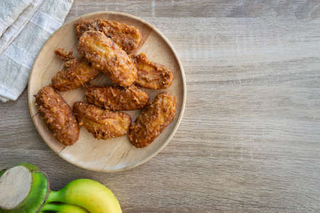 Deep fried banana in wooden dish with banana on table.の写真素材