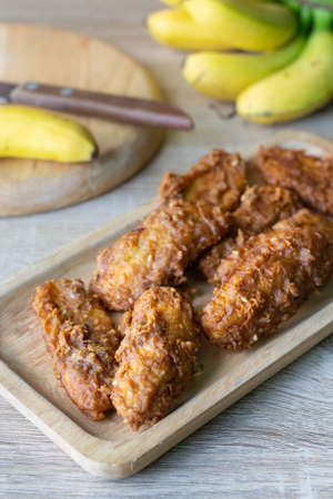 Deep fried banana in wooden dish with banana on table.の写真素材