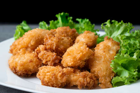 Fried chicken and lettuce in white dish on table.の写真素材