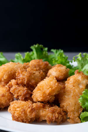 Fried chicken and lettuce in white dish on table.の写真素材