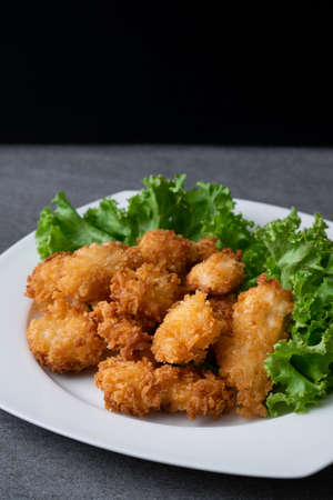 Fried chicken and lettuce in white dish on table.の写真素材