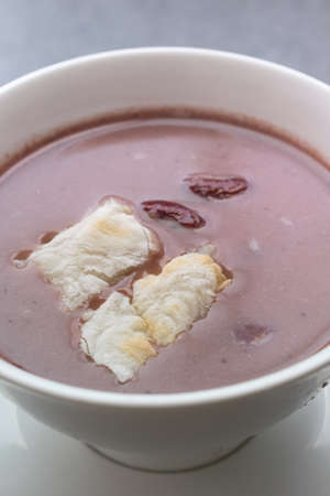 Grill mochi with boiled red beans in white bowl on table.の写真素材