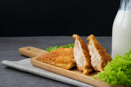 Deep fried sandwich stuffed tuna in wooden dish on table.の写真素材