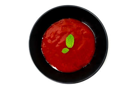 Tomato sauce in black bowl with mint leaves  isolated on white background.の写真素材