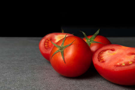 Group of haft tomatoes sliced on concrete table.の写真素材