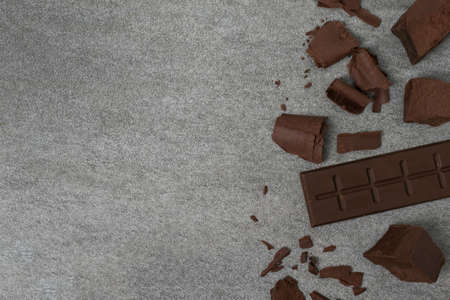 Broken chocolate with small piece on tile table.の写真素材