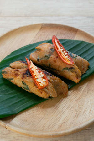 Grilled fish with curry paste and coconut milk on banana leaf in wooden dish,Thai food.の写真素材