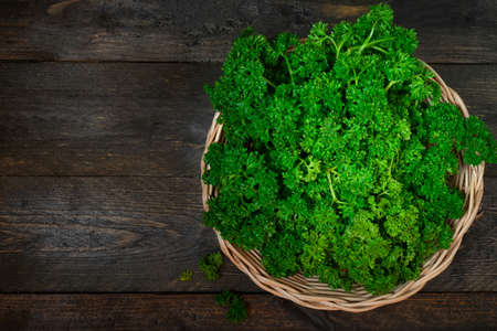Parsley in basket on wooden table.の写真素材