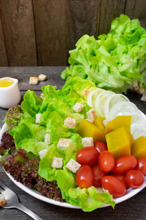 Fresh salad with green oak in white dish on wooden table.の写真素材