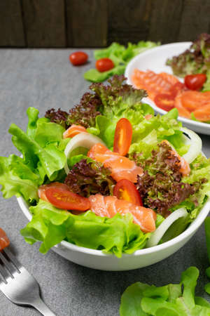 Salmon salad with green oak,onion and tomato on concrete table.の写真素材
