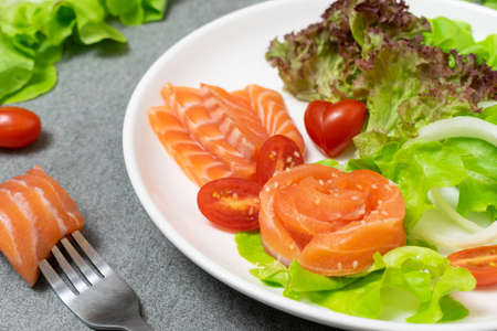 Salmon salad with green oak,onion and tomato on concrete table.の写真素材