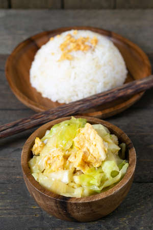 Fried cabbage and fried egg in oyster sauce, Rice in wooden dish.の写真素材