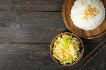 Fried cabbage and fried egg in oyster sauce, Rice in wooden dish.の写真素材