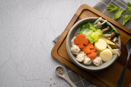 Vegetables soup with chicken ball and egg tofu in gray bowl on concrete table.の写真素材