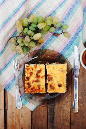 cheese casserole in the dish with green grapes on a wooden backgroundの写真素材
