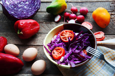 Fresh salad with cherry tomatoes, spinach, in a plate on wooden backgroundの写真素材