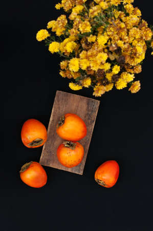 Fresh ripe persimmons on a black backgroundの写真素材