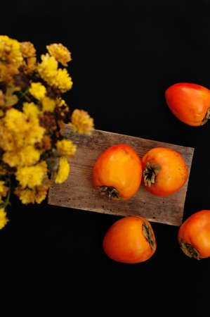 Fresh ripe persimmons on a black backgroundの写真素材