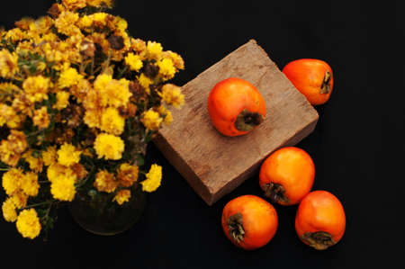 Fresh ripe persimmons on a black backgroundの写真素材