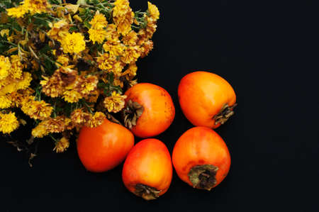 Fresh ripe persimmons on a black backgroundの写真素材