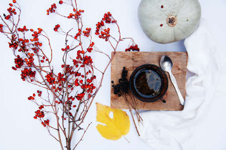 Branches with red berries hawthorn and white cup of tea on white backgroundの写真素材