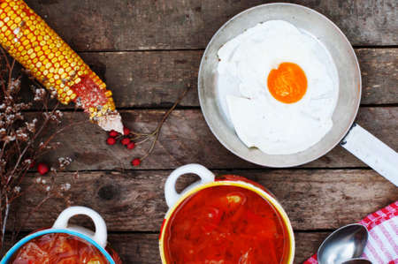 Traditional Ukrainian Russian vegetable borscht on the old wooden background. Ukrainian and russian red-beet soup borscht with garlic. Breakfast. Rustic food style.の写真素材