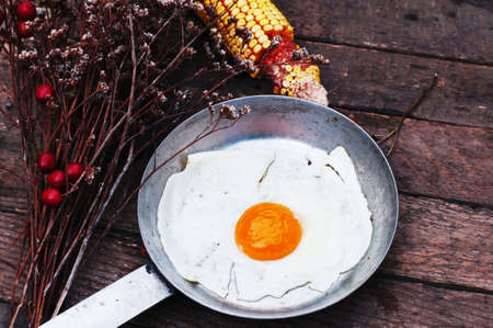 Fried eggs in a frying pan on wooden background. Breakfast. Healthy food. Fried eggs. Fried egg on a...