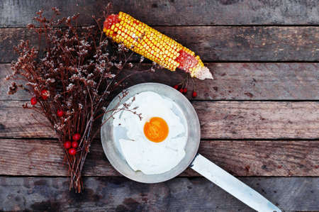 Fried eggs in a frying pan on wooden background. Breakfast. Healthy food. Fried eggs. Fried egg on a pan. Rustic food style. Ripe corn. Food and drink.の写真素材