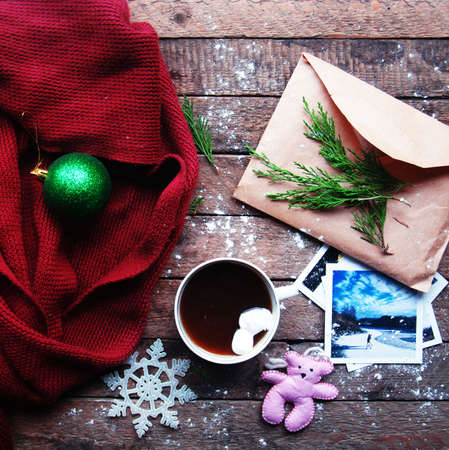 Winter decoration. Composition on wood background. Hot tea, candles, cut grapefruit. Christmas. Christmas mood. Christmas spirit. Fir branches. Tangerine slices. Conesの写真素材