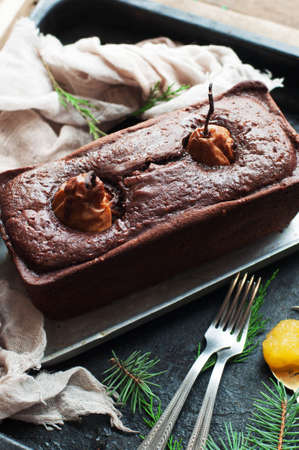 Pear pie sprinkled with powdered sugar on a black background. Beautiful chocolate pear tart in...