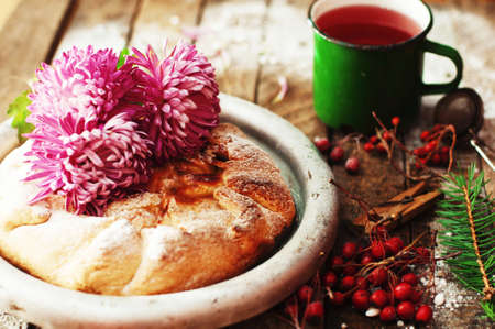 Pear pie sprinkled with powdered sugar on a black background. Beautiful chocolate pear tart in...