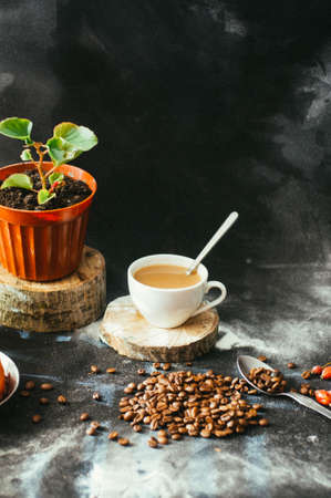 Close-up of coffee cup with roasted coffee beans on black background.の写真素材