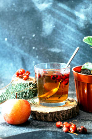 Freshly brewed tea in glass cup on blue background. Orange hot drink, selective focus.の写真素材