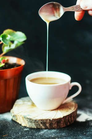 Close-up of coffee cup with roasted coffee beans on black background.の写真素材