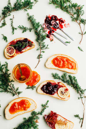 Homemade sandwiches with peach and cherry jam on a white background. It is decorated with fir branches. Butter and Jelly Sandwich. Flat lay.の写真素材
