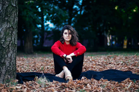 Portrait of exquisite beautiful young girl in a red blouse. Beautiful  portrait of a girl.の写真素材