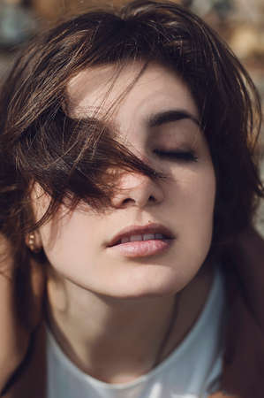 Portrait of a beautiful young girl outdoors. Outdoors portrait of beautiful young brunette woman looking at camera.の写真素材