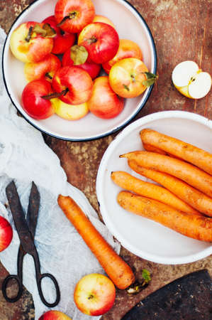 Apples, carrots, beet, cabbage, grapefruit, lemon sliced above rustic wooden table. Detox and healthy breakfast.の写真素材