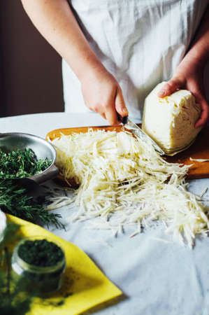 Vegetarians and cooking. Ladies hand cut green vegetable, ready to prepare healthy salad. Country style. Dieting  concept. Woman cooking. Housewife who enjoys cookingの写真素材