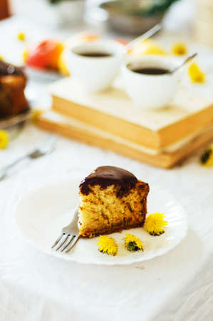 Traditional homemade chocolate cake. Rustic style and natural light. Chocolate Mud Cake  on White table. Piece of chocolate cake with icing. Vanilla Cake with Chocolate Glaze.の写真素材