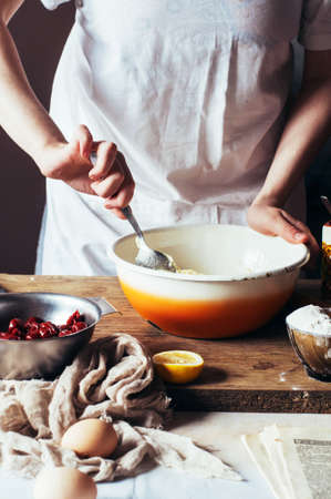 Steps of making cooking sandy cake with cherry filling : mixing ingredients: bowl, flour, eggs,  sour cream.の写真素材