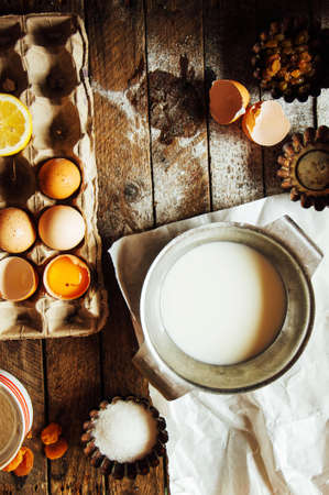 Baking cake ingredients - bowl, flour, eggs, egg whites foam, eggbeate on wood chalkboard from above.の写真素材