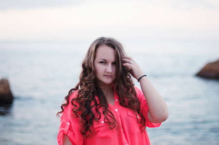 Portrait of a beautiful young girl of 20 years old in a summer dress outdoors in summer parkの写真素材